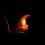 lighted candle in the dark