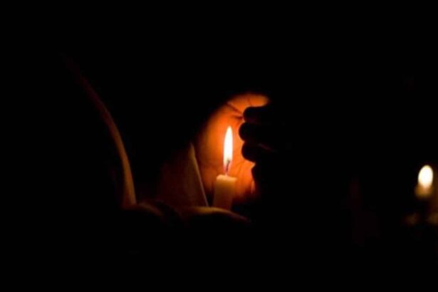 lighted candle in the dark