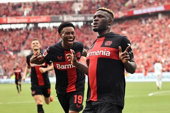 Victor Boniface celebrates a goal for Bayer Leverkusen as Nathan Tella joins him