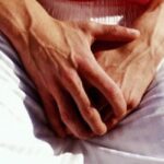 man holding his genitals area