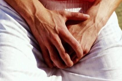 man holding his genitals area