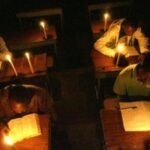 students studying in the dark with candle lights