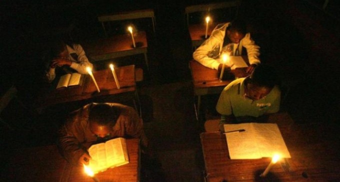 students studying in the dark with candle lights
