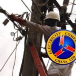 Officer of Electricity Company of Ghana working on a light pole