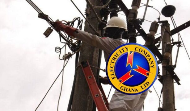 Officer of Electricity Company of Ghana working on a light pole